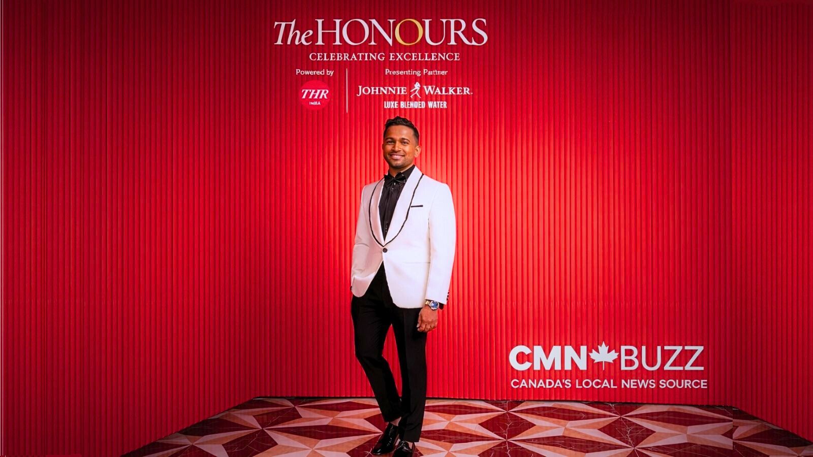 Basil Joseph at The Honours by The Hollywood Reporter India in Mumbai, wearing a white tuxedo against a red backdrop.